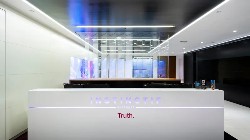 Backlit branded reception desk at Instinctif Partners London by K2 Space