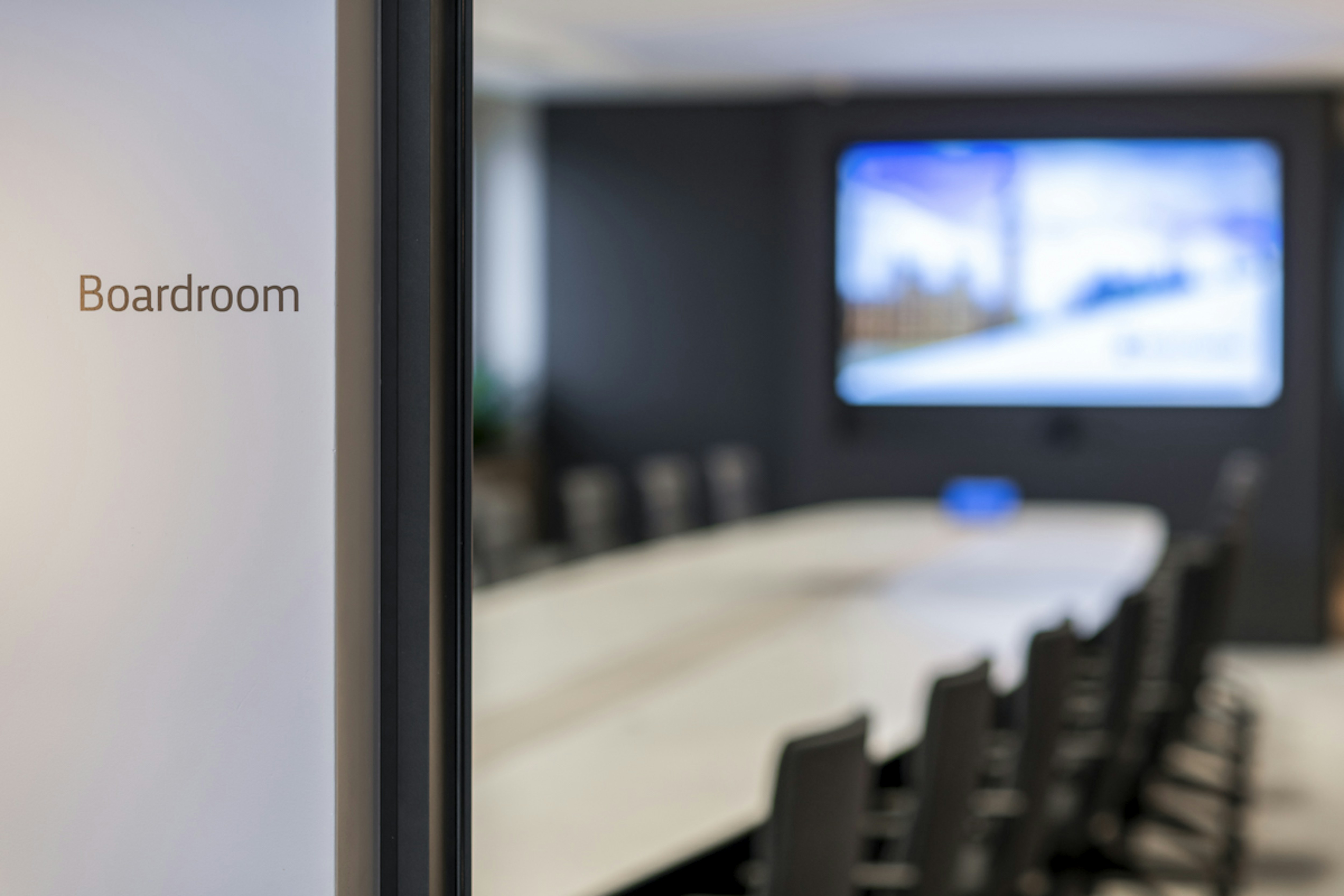 Global Private Investment Firm - Boardroom with Corian table, black chairs, and greenery accents - SMALL-8