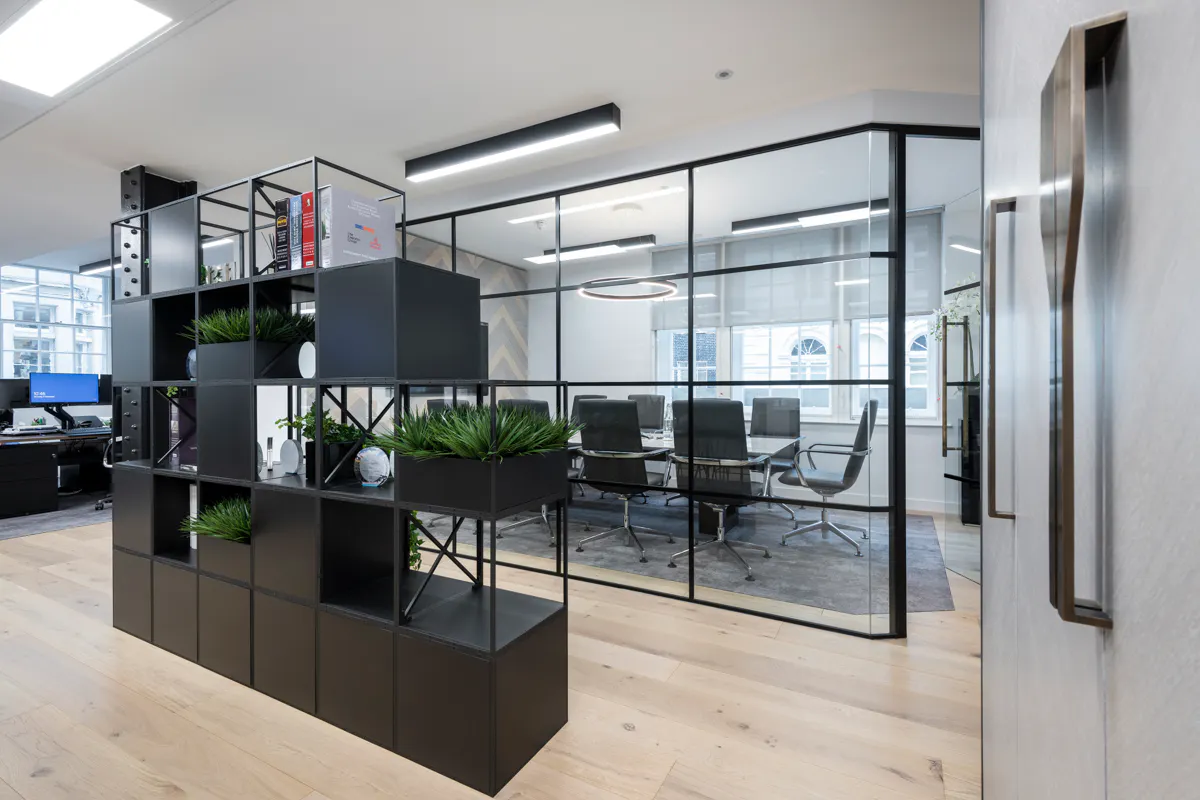 Modular black shelving and greenery dividers at Altum Capital London, reconfigurable to suit changing team needs by K2 Space