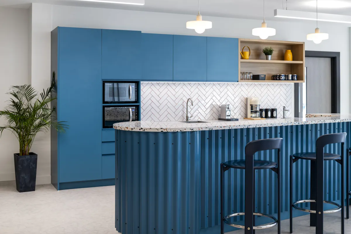 Social Kitchen and Tea Point — Oil Spill Response (OSRL) by K2 Space Social kitchen and kitchenette with bar stool seating at Oil Spill Response (OSRL), designed as the social heart of the floor by K2 Space