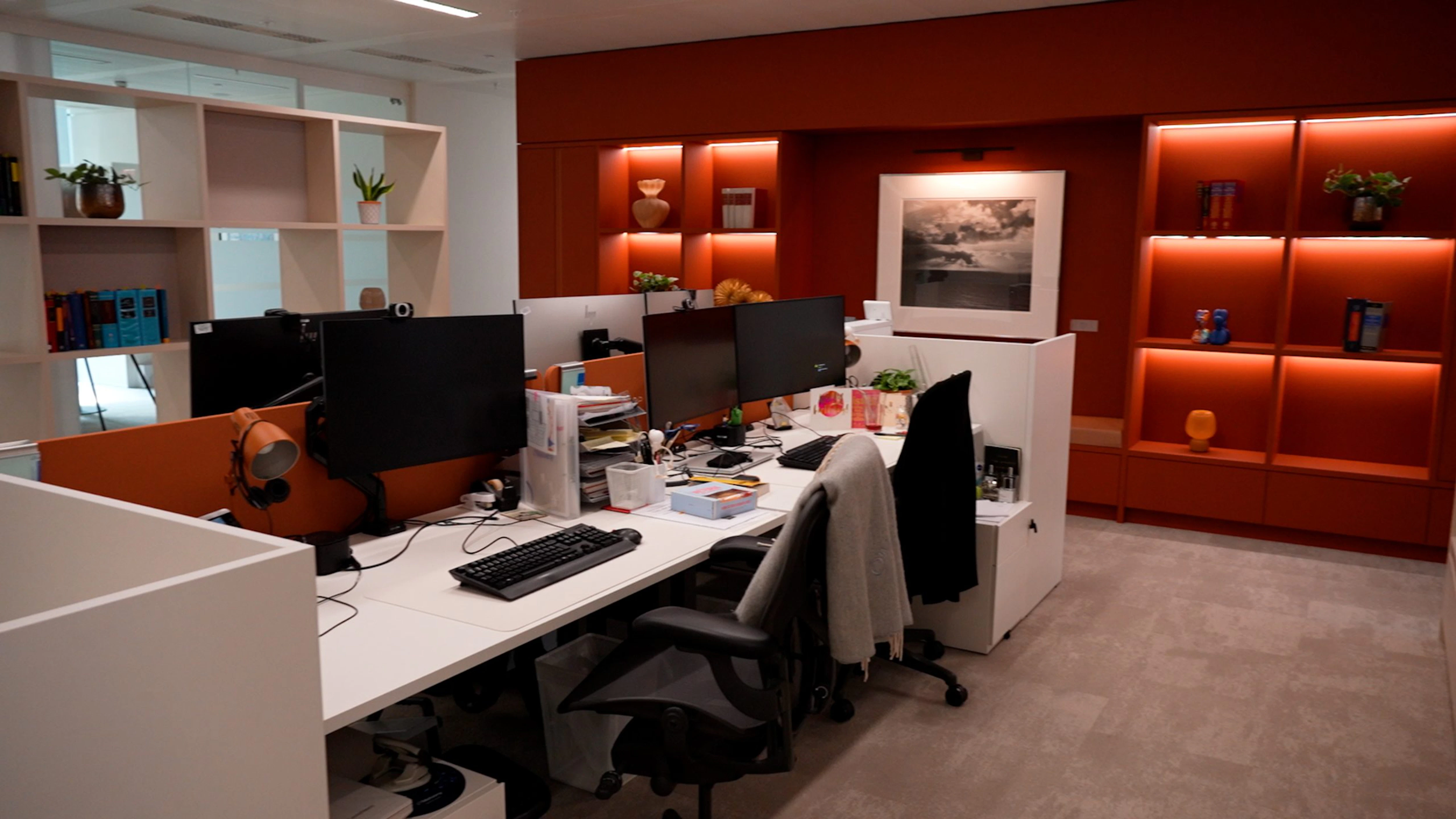 OMelveny – Open Plan Workstations with Orange Display Niches